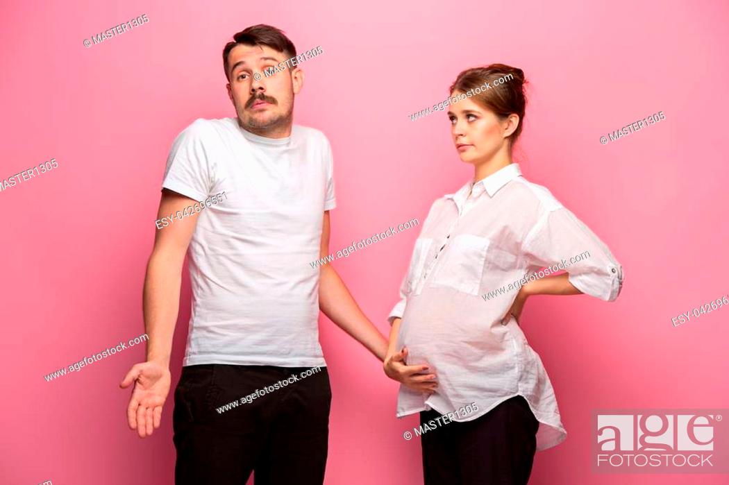 The funny handsome man and his beautiful pregnant wife at pink studio  background, Stock Photo, Picture And Low Budget Royalty Free Image. Pic.  ESY-042696551 | agefotostock