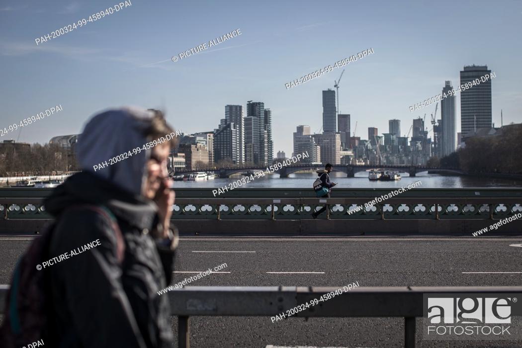 Stock Photo: 24 March 2020, England, London: People walk on Westminster Bridge on the first day of a nationwide lockdown. Photo: Oliver Weiken/dpa.