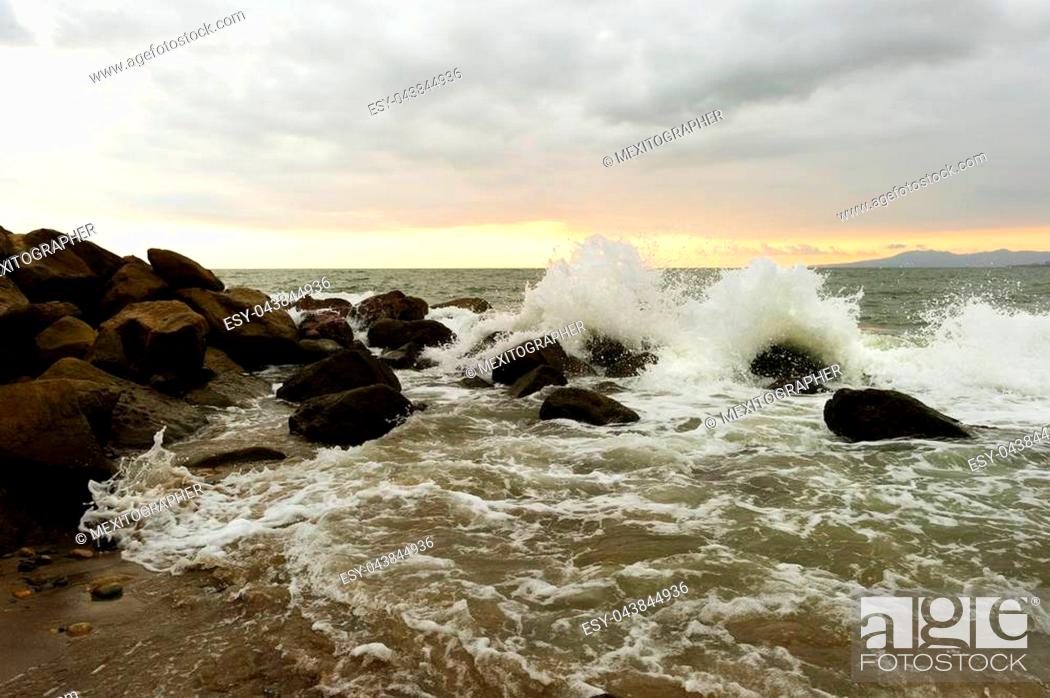 Photo de stock: Waves crashing is an ocean wave rushing to shore hitting sea rocks and shooting up into the air as ocean spray.