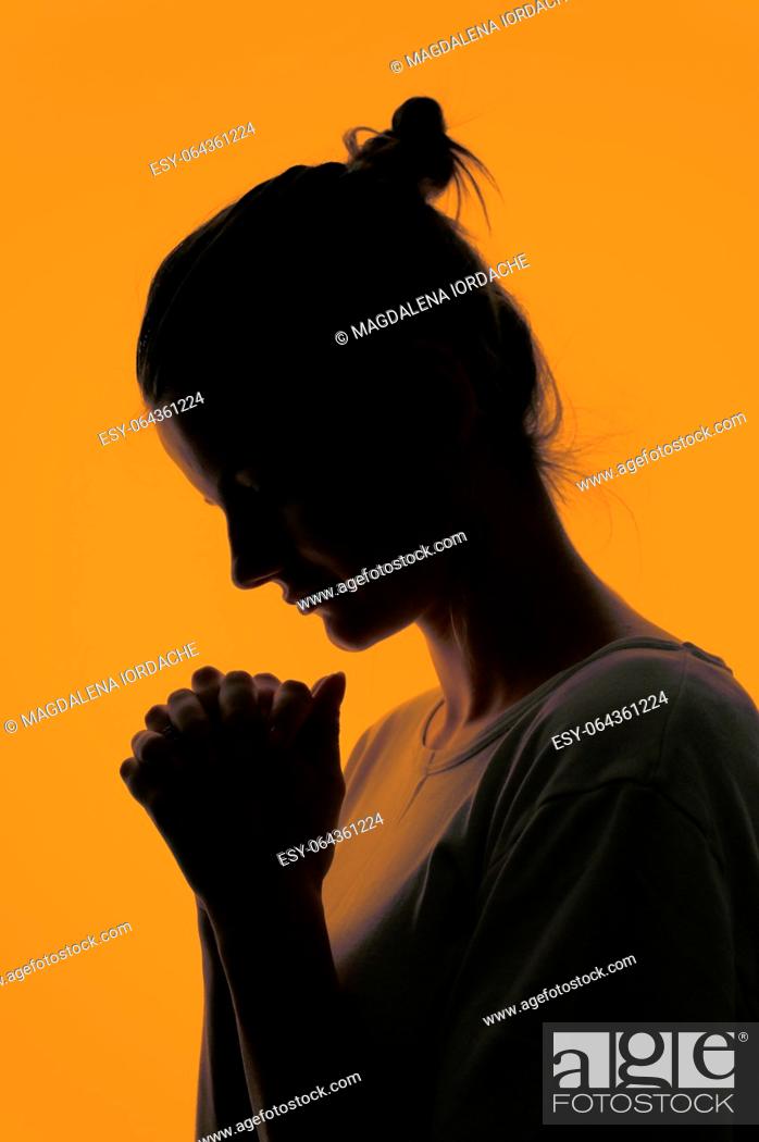 Stock Photo: Closeup Profile Of A Woman Praying In Silhouette Isolated in Studio.