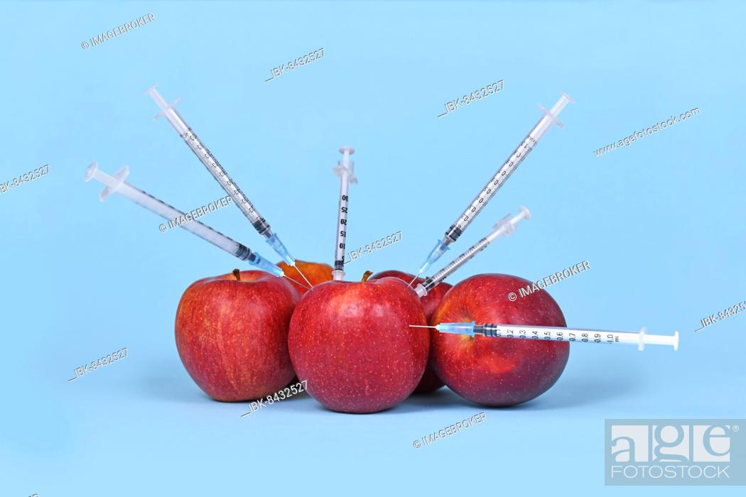 Stock Photo: Multiple apple fruits being injected with syringes. Concept for genetically modified organism.