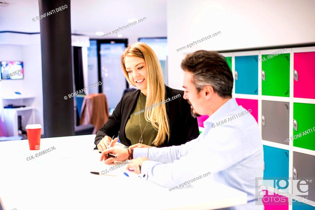 Stock Photo: Businesswoman and man having brainstorming meeting in office.