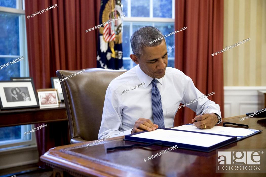 Stock Photo: United States President Barack Obama signs House Joint Resolution 124, the Continuing Appropriations Resolution, 2015, in the Oval Office of the White House in.