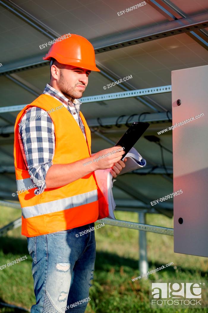 Stock Photo: Foreman checking the process of installation of solar panels. Engineer installing photovoltaic panels.
