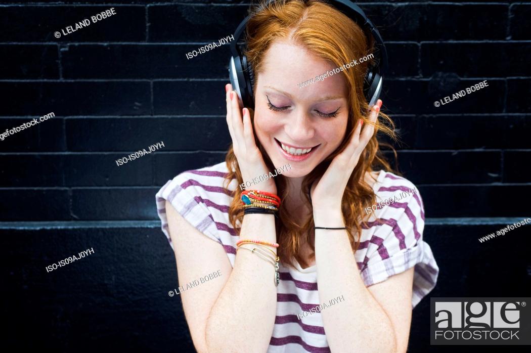 Stock Photo: Portrait of young woman wearing headphones.