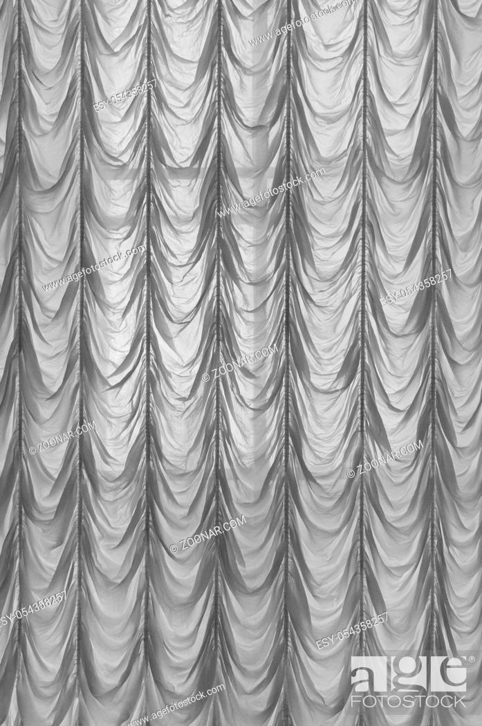 Stock Photo: White curtains. Long, white, semy see-through curtains hanging in the window. Closeup of white waving curtain on window in white bedroom.