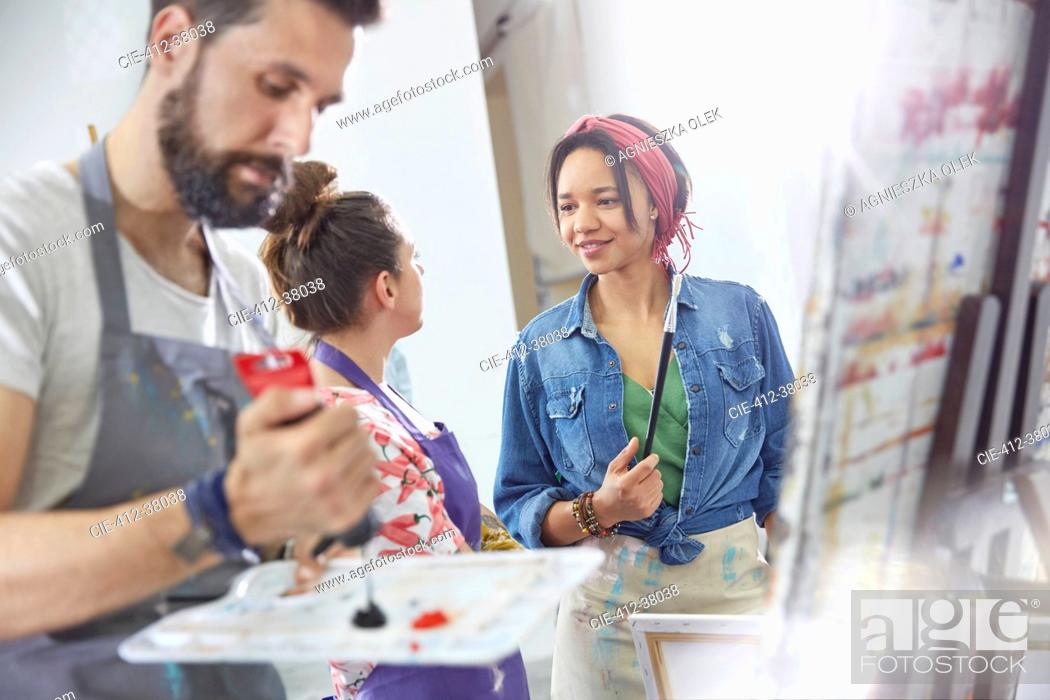 Photo de stock: Artists talking and painting in art class studio.