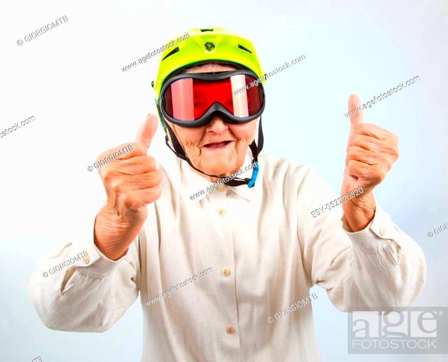 funny grandma wearing a yellow bicycle helmet and ski goggles and showing thumbs  up, Stock Photo, Picture And Low Budget Royalty Free Image. Pic.  ESY-052226820 | agefotostock