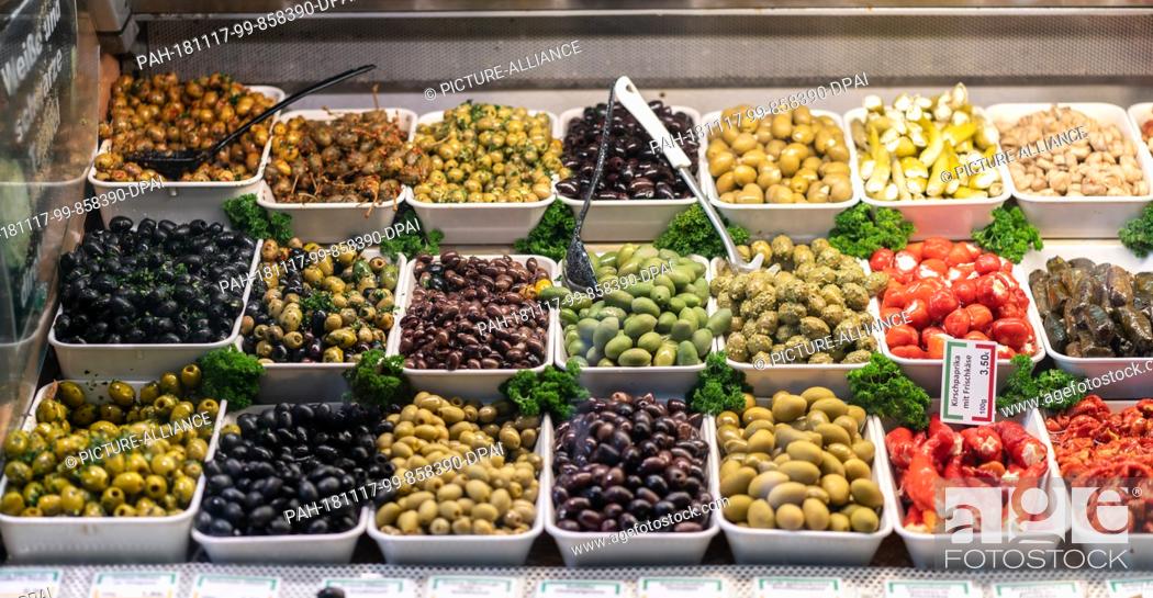 Stock Photo: 17 November 2018, Hessen, Frankfurt/Main: Olives and stuffed tomatoes are for sale at a stand in Frankfurt's Kleinmarkthalle.