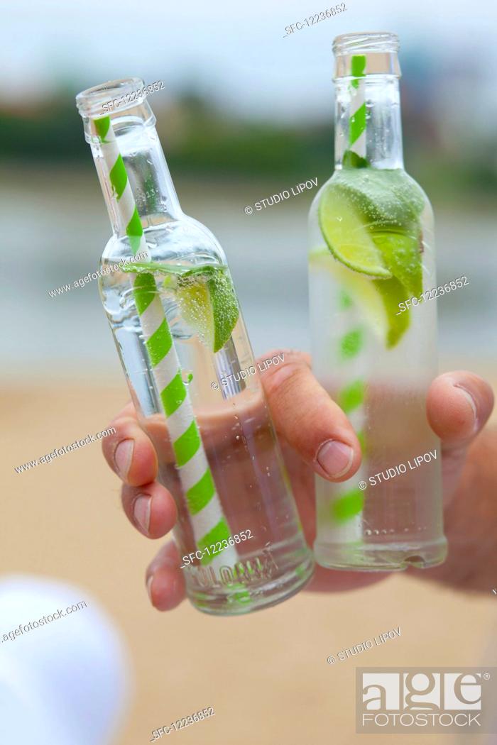 Stock Photo: A man holding two bottles of Virgin Mojito.