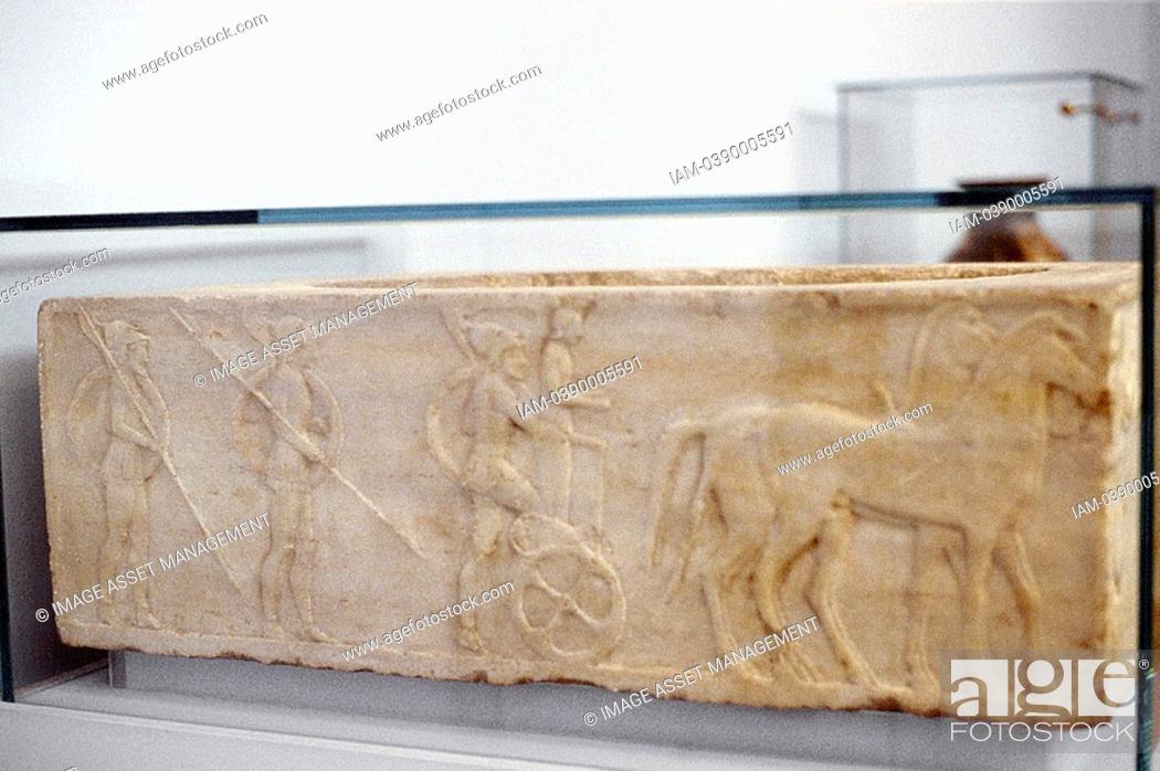Stock Photo: Ancient Greek warrior stepping into his chariot  Behind him are two hoplites carrying shields and spears  Hoplites formed the heavily armoured Greek infantry.