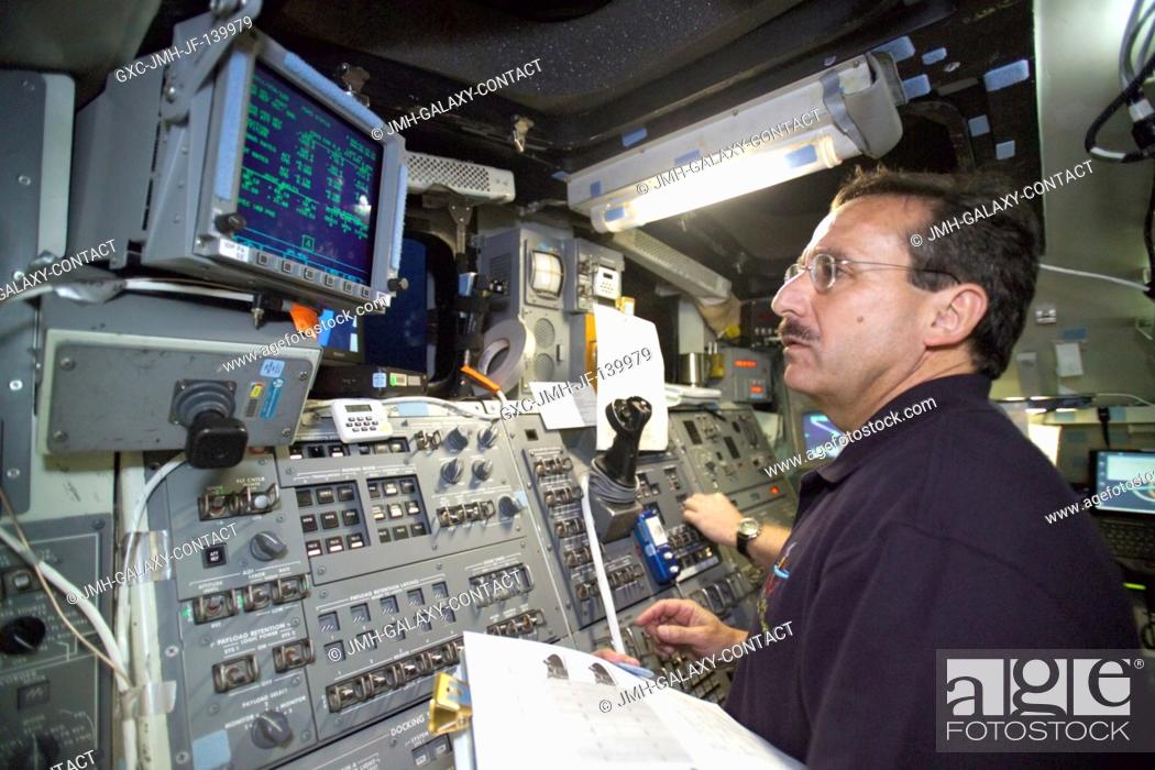 Stock Photo: Astronaut Charles J. Camarda, STS-114 mission specialist, checks data on a monitor in the aft section of the cabin of the fixed-base shuttle mission simulator.