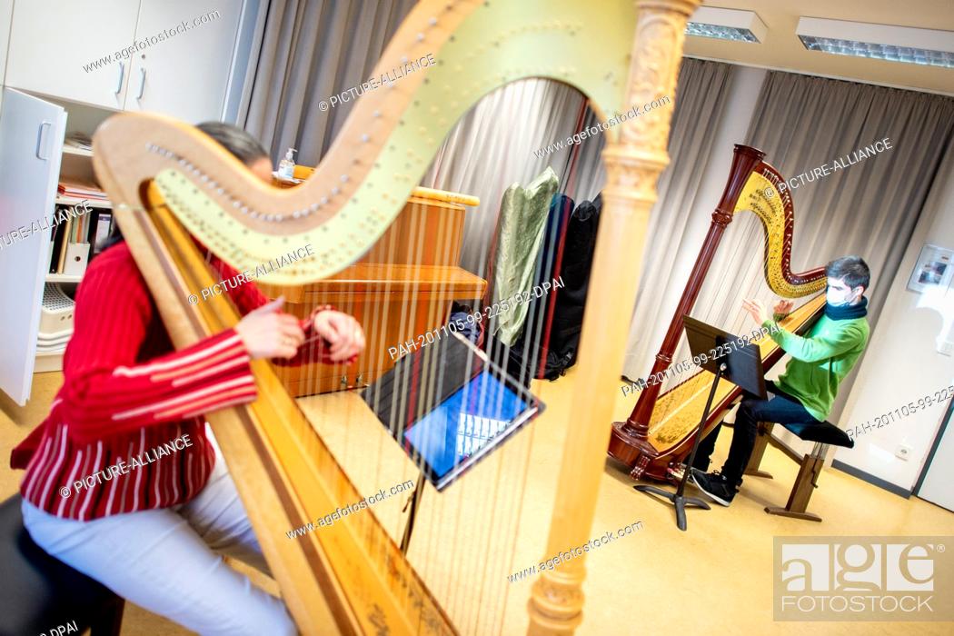 Stock Photo: 03 November 2020, Lower Saxony, Hanover: Music student Malik Vollmer plays his harp during a lesson at the municipal music school.