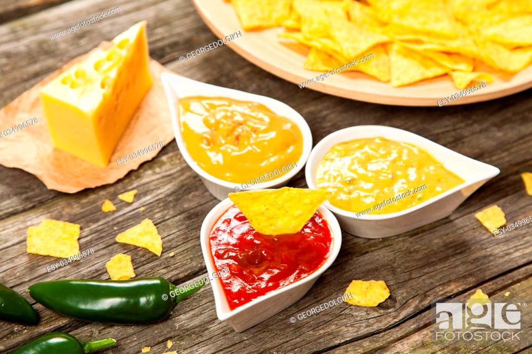 Stock Photo: Plate of nachos with salsa, cheese and guacamole dips.