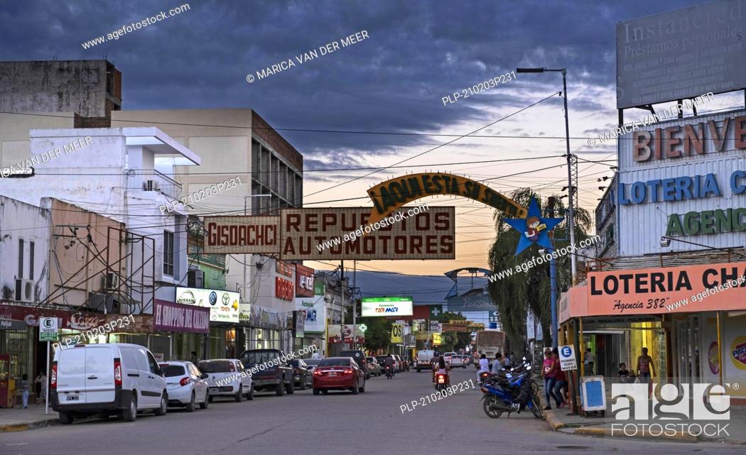 Stock Photo: Traffic and shops in the shopping street at sunset in the city Presidencia Roque Sáenz Peña / Saenz Pena in the Chaco Province, Argentina.