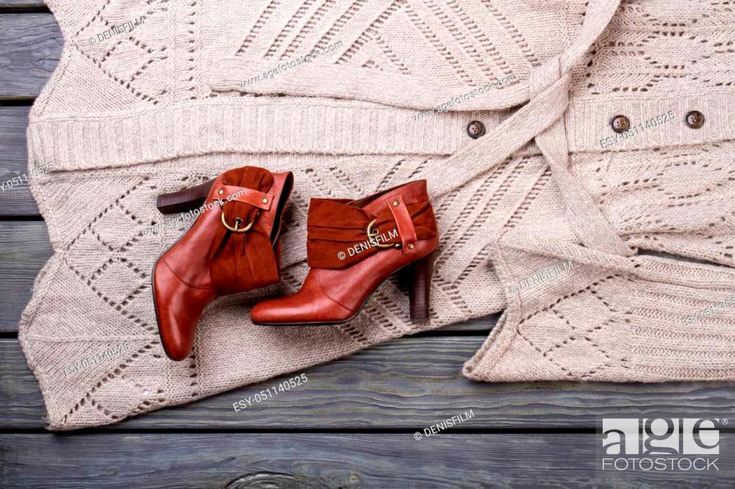 Stock Photo: Pair of brown heel footwear. Wooden desk surface background.