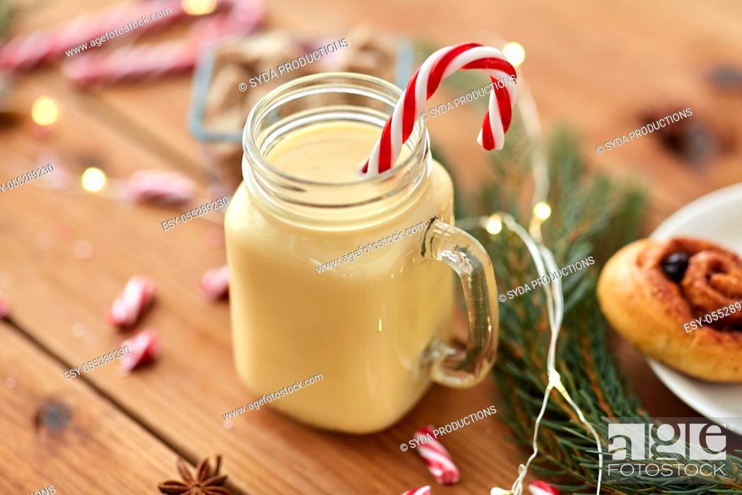 Stock Photo: eggnog with candy cane in mug and cinnamon buns.