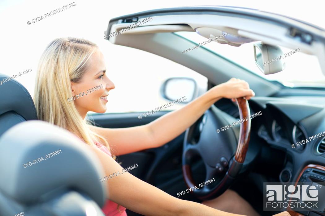 Stock Photo: happy young woman driving convertible car.