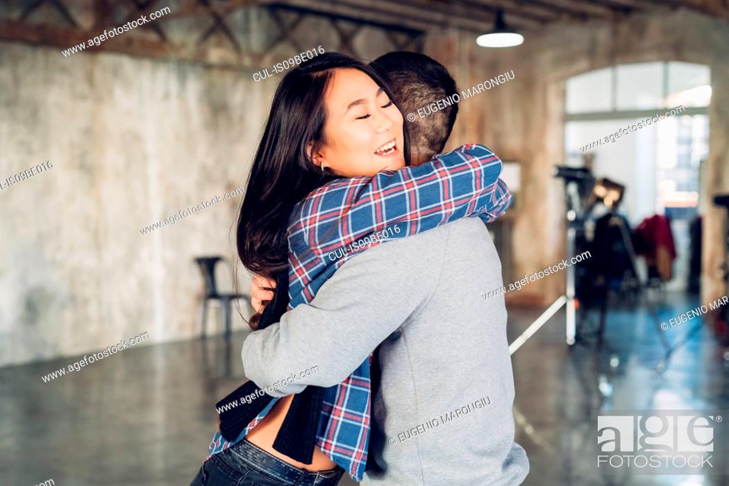 Stock Photo: Couple hugging in open plan studio.