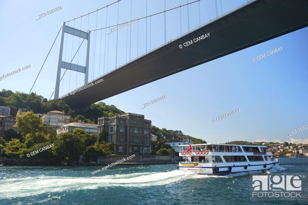 Stock Photo: Touristic cruise boat in front of the Rumelihisari (also known as Rumelian Castle and Roumeli Hissar Castle) village under the Bosphorus bridge at the European.