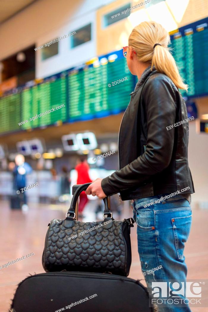Stock Photo: Female traveller checking flight departures board.