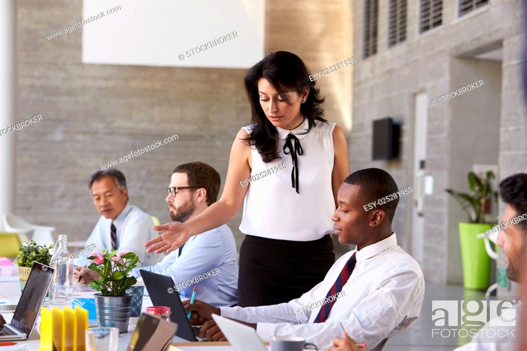 Stock Photo: Businesswoman Working With Colleagues At Boardroom Table.