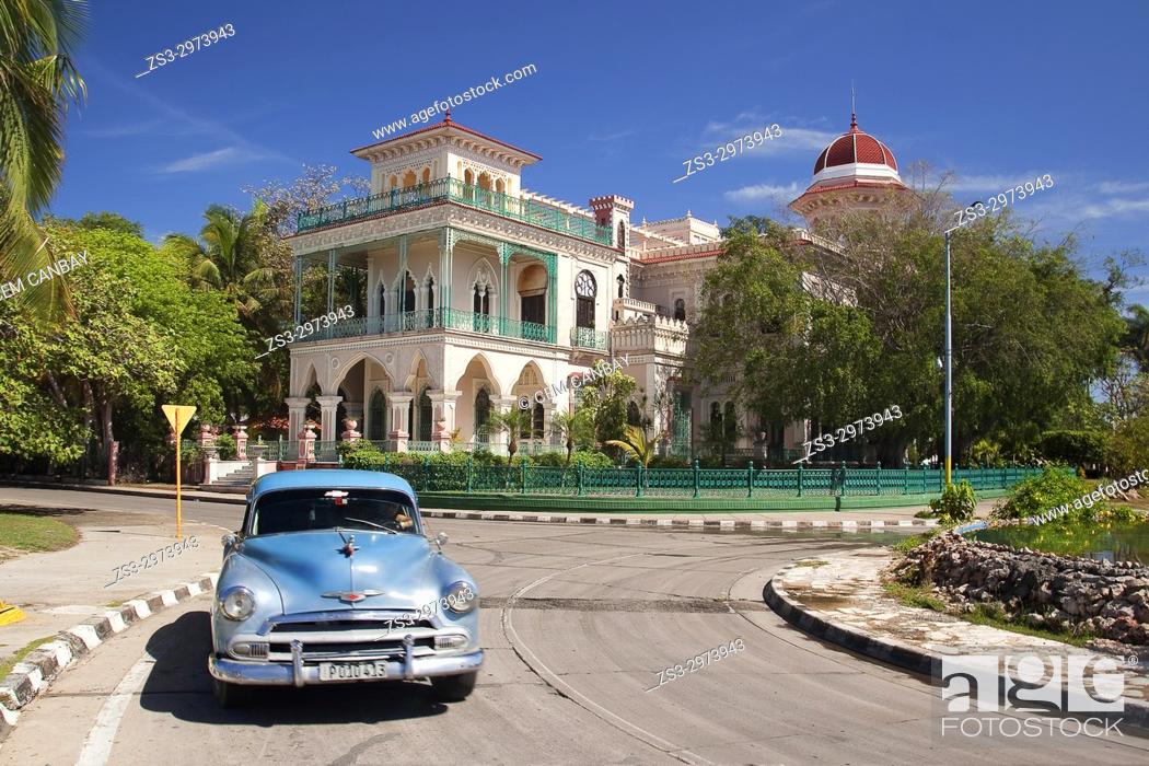 Stock Photo: Old American car in front of the Palacio De Valle -Valle's Palace In Punta Gorda district, Cienfuegos, Cuba, West Indies, Central America.