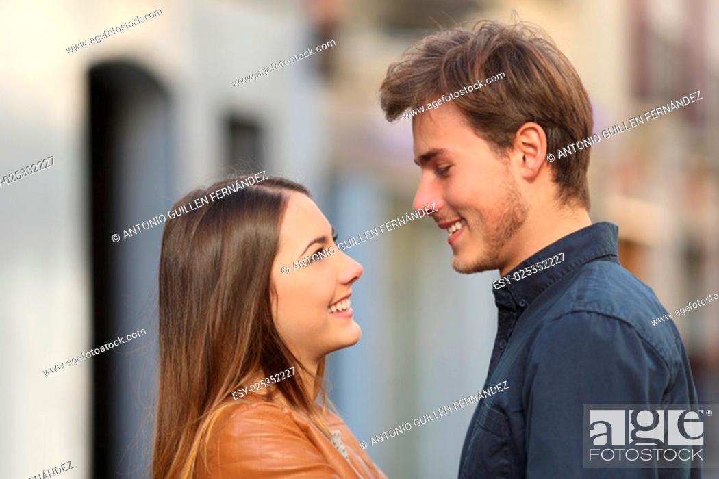 Stock Photo: Profile of a happy couple looking each other affectionate in the street.