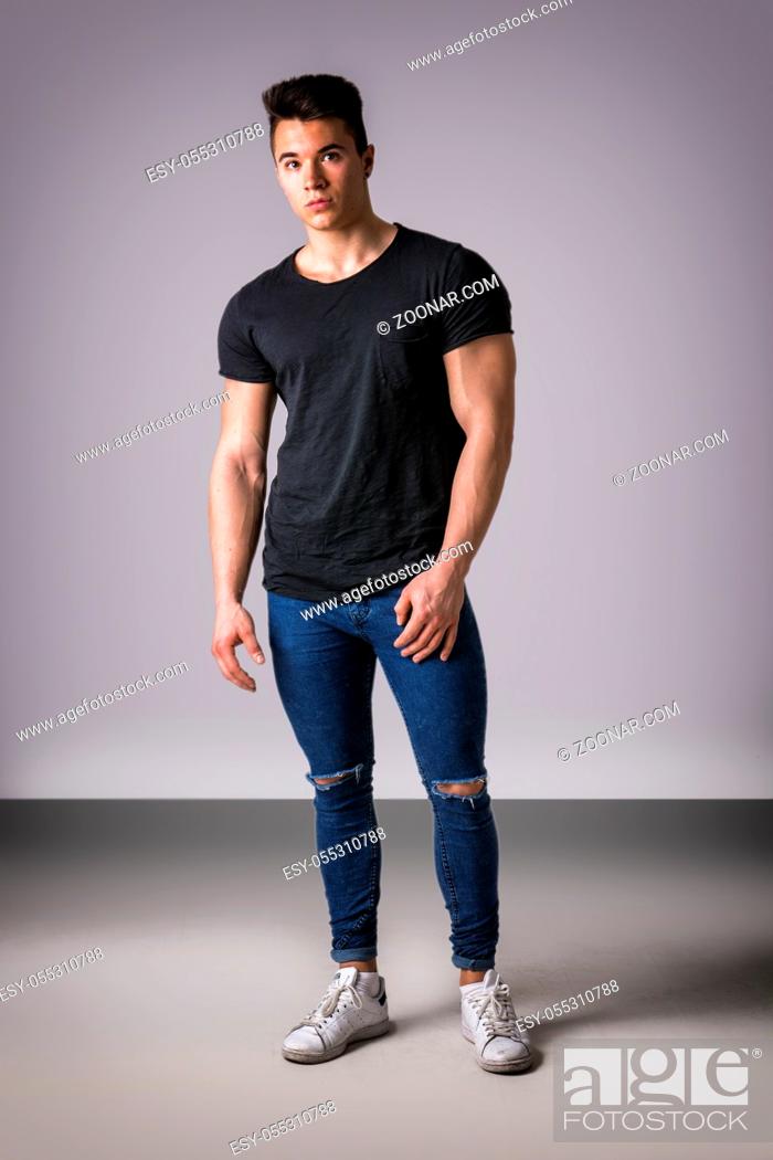Stock Photo: Handsome young muscular man looking at camera in studio shot over neutral background. full length body shot.