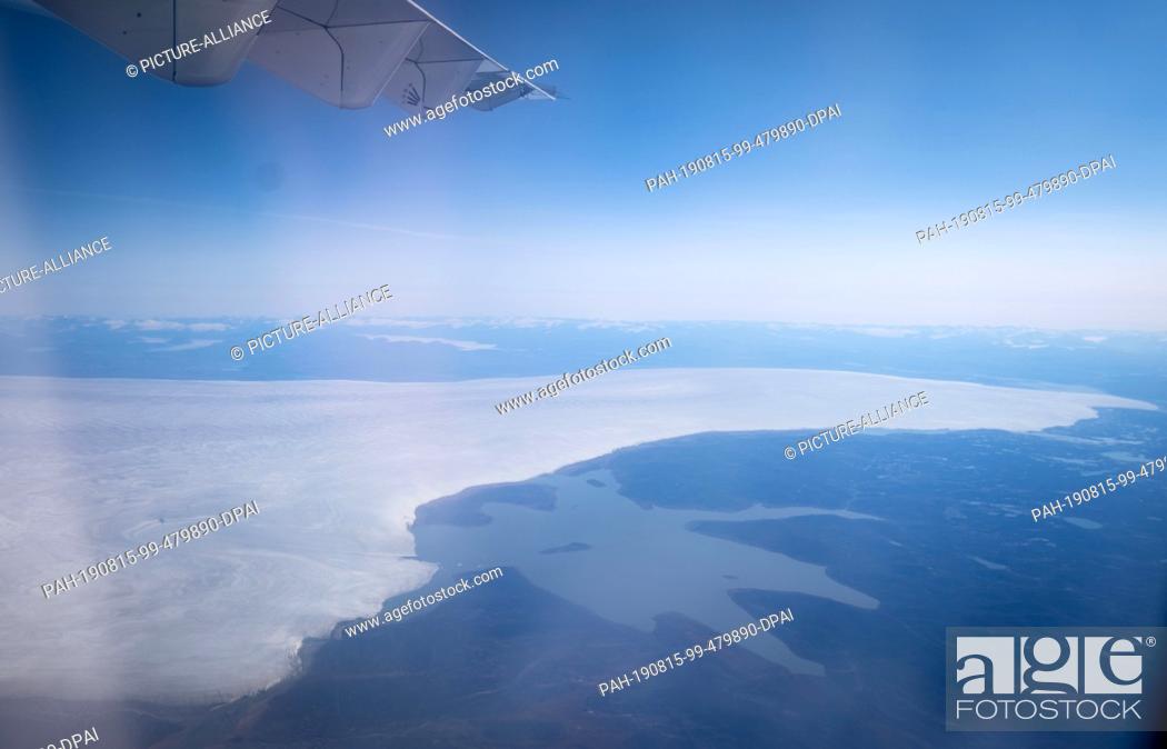 Stock Photo: 15 August 2019, Canada, Iqaluit: A huge ice cap can be seen on the flight to Pond Inlet, in the Canadian Arctic, from the window of a charter plane.