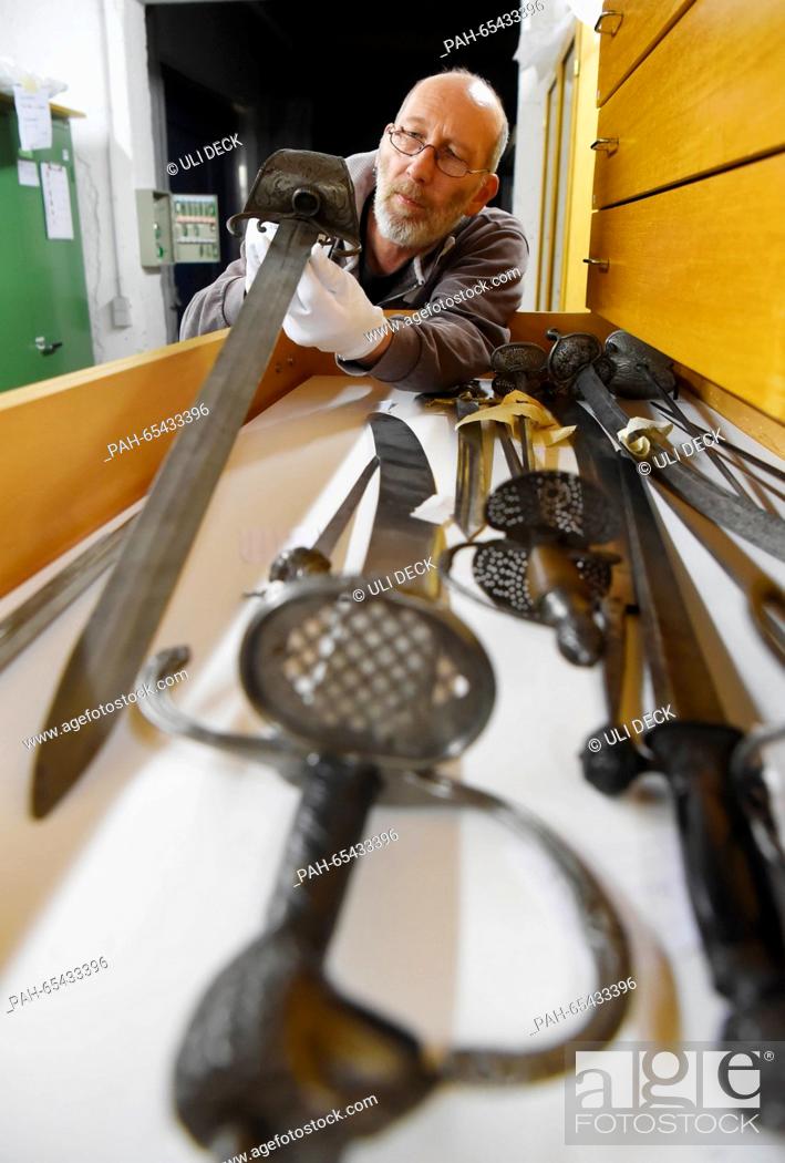 Stock Photo: Detlef Sippel, metal restorer at the Badisches Landesmuseum Karlsruhe, standing by a cupboard with cutting and stabbing weapons from the 16th-18th centuries in.