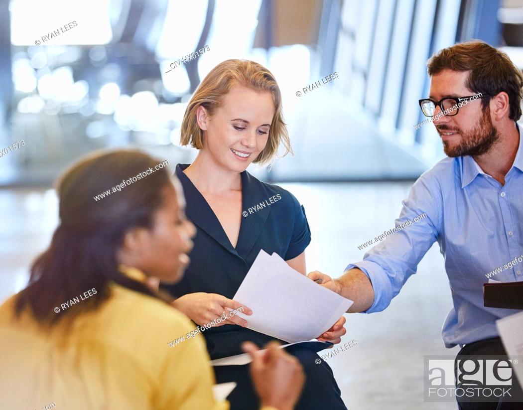 Stock Photo: Business people discussing paperwork in meeting.