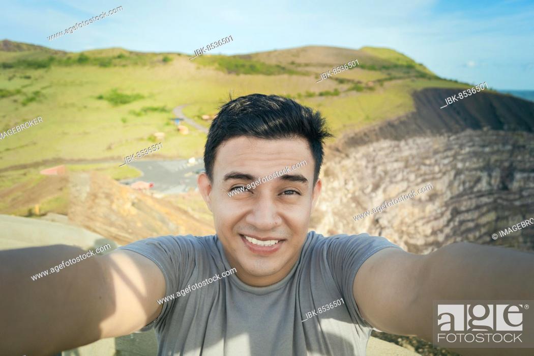 Stock Photo: Adventurous man taking a selfie at a viewpoint. Close up of person taking an adventure selfie, Tourist taking a selfie at a viewpoint.