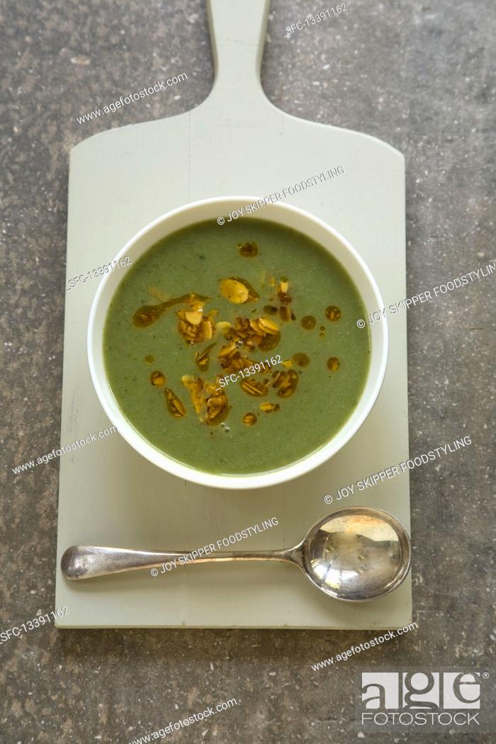 Stock Photo: Green vegetable soup with chillied almond garnish.