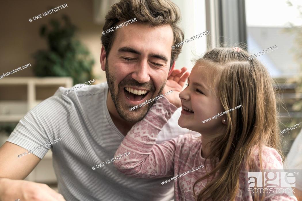 Stock Photo: Little girl stroking laughing man's cheek.