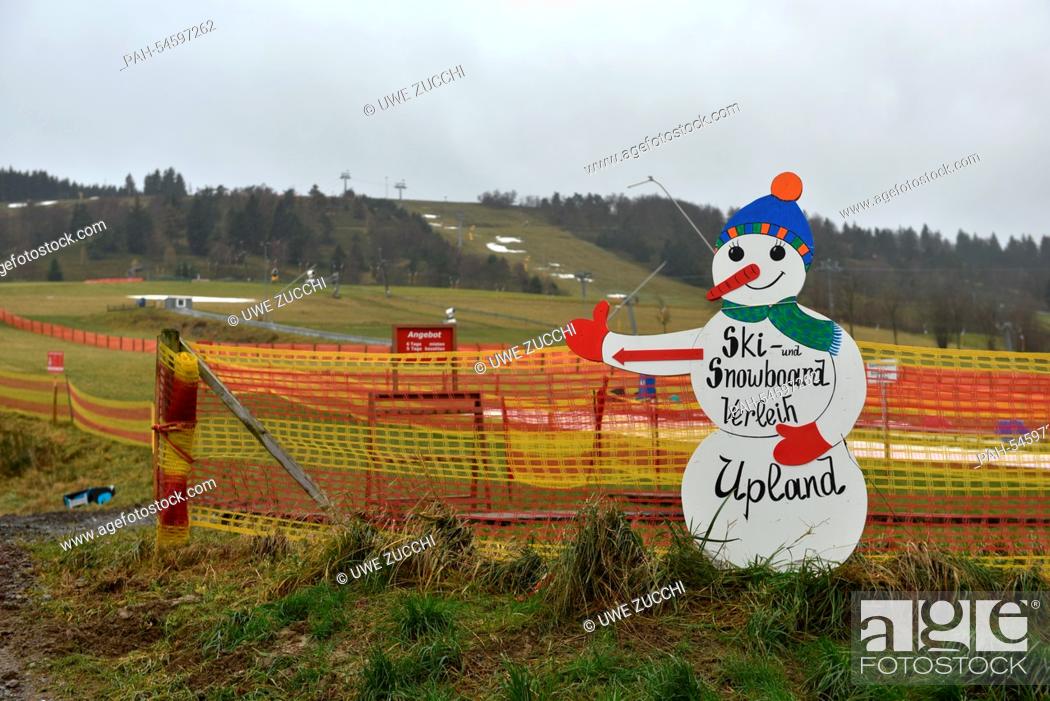 Stock Photo: A snowman figure advertizes a ski and snowboard rental in front of green meadows in Willingen, Germany, 23 December 2014.