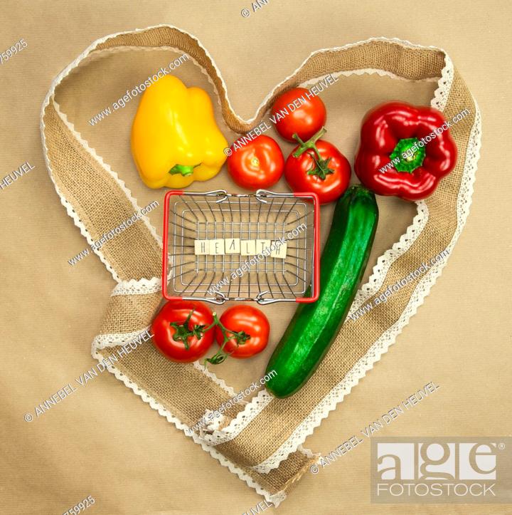 Stock Photo: Fresh organic vegetables with the word Health in shopping basket surrounded with ribbon heart on brown craft paper top view, Health, vegan.