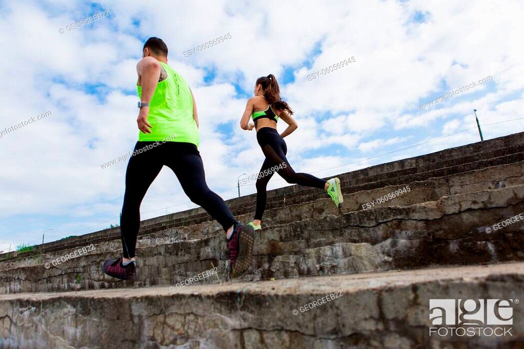 Stock Photo: Sporty young couple in stylish sportswear running on stairs, photography for blog or ad of sport and healthy lifestyle. High quality photo.