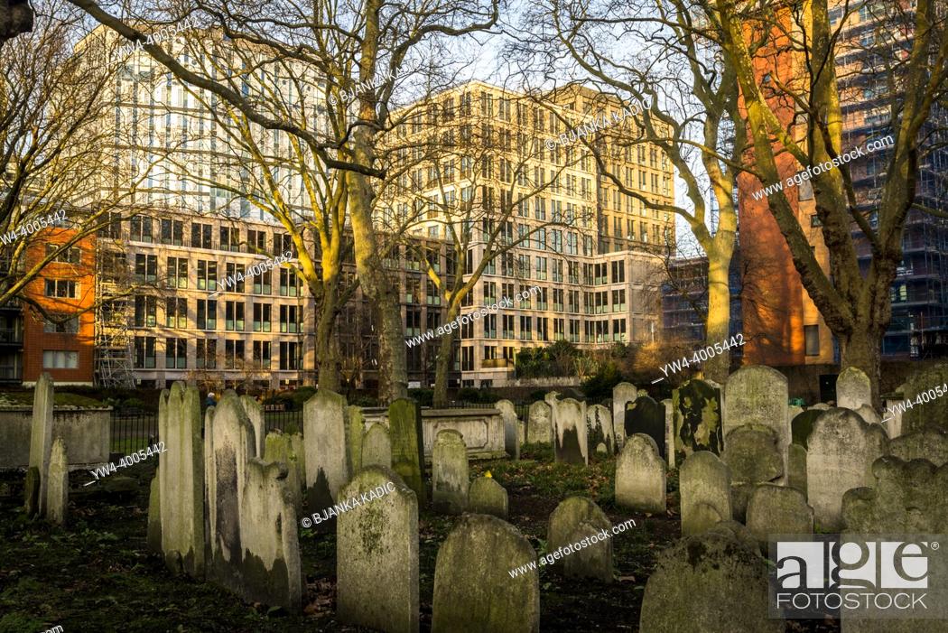 Stock Photo: Bunhill Fields burial ground and surrounding modern office and residential buildings. It is a former cemetery established in 1665, London, England, UK.