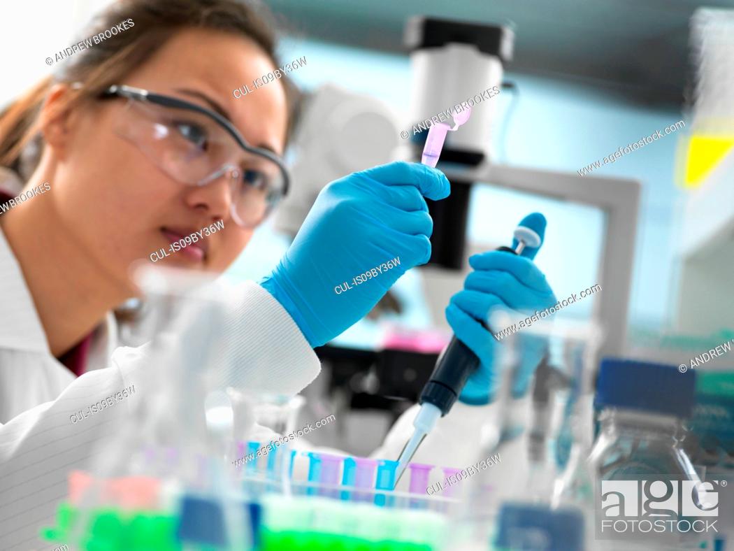 Stock Photo: Scientist pipetting sample into vial for genetic testing in laboratory.