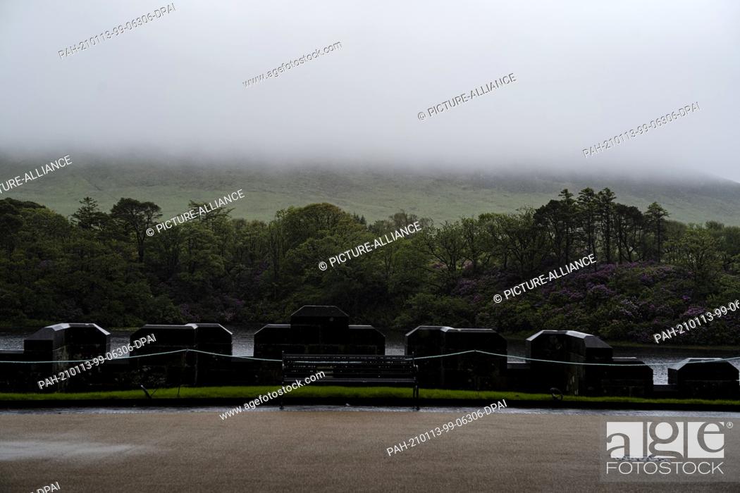 Stock Photo: 29 May 2019, Ireland, Connach: A view from the Kylemore Abbey estate of Pollacapul Lough near Ireland's cloud-covered Connemara National Park.