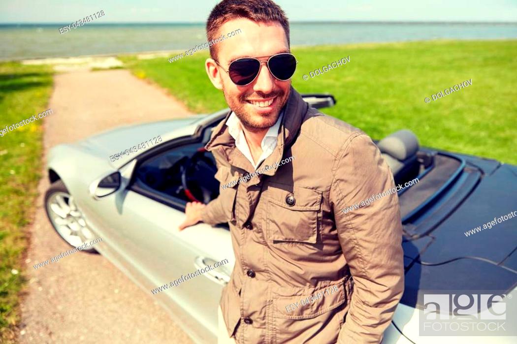 Stock Photo: road trip, travel, transport, leisure and people concept - happy man near cabriolet car outdoors.