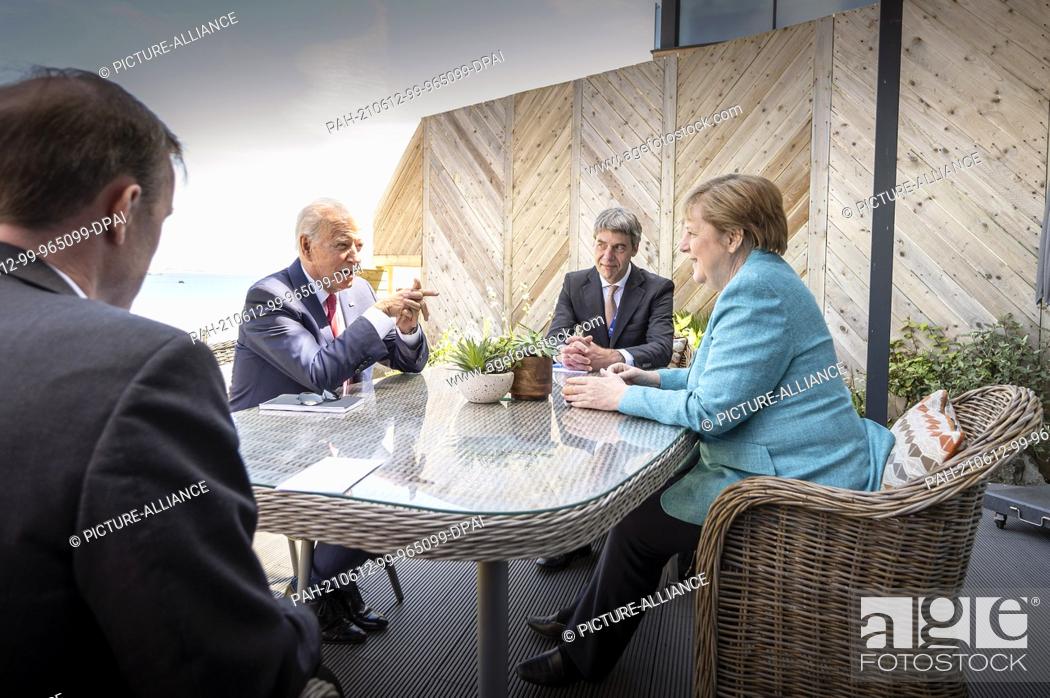 Stock Photo: HANDOUT - 12 June 2021, United Kingdom, St.Ives: German Chancellor Angela Merkel (CDU) and US President Joe Biden (2nd from left) sit with their foreign policy.