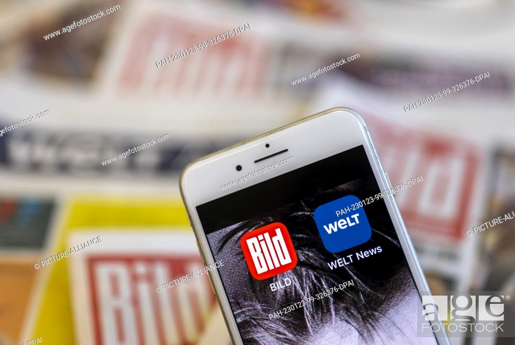 Stock Photo: 23 January 2023, Berlin: The apps of the newspapers ""Bild"" and ""Die Welt"" can be seen on the screen of a smartphone, while the paper editions of the.
