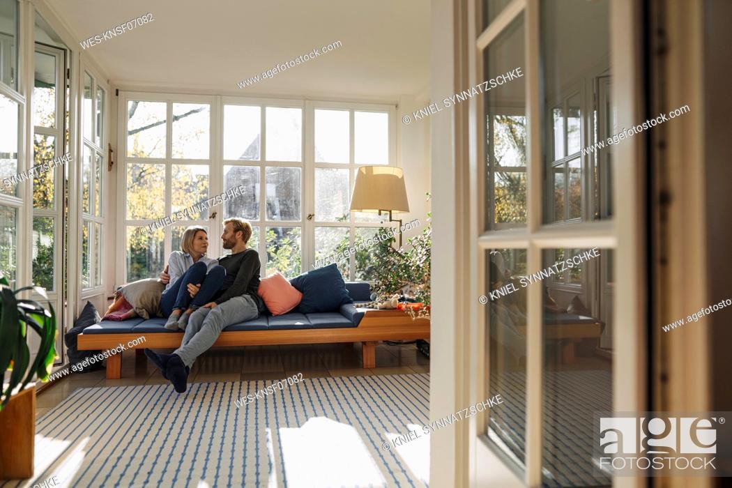 Stock Photo: Affectionate couple relaxing in sunroom at home.