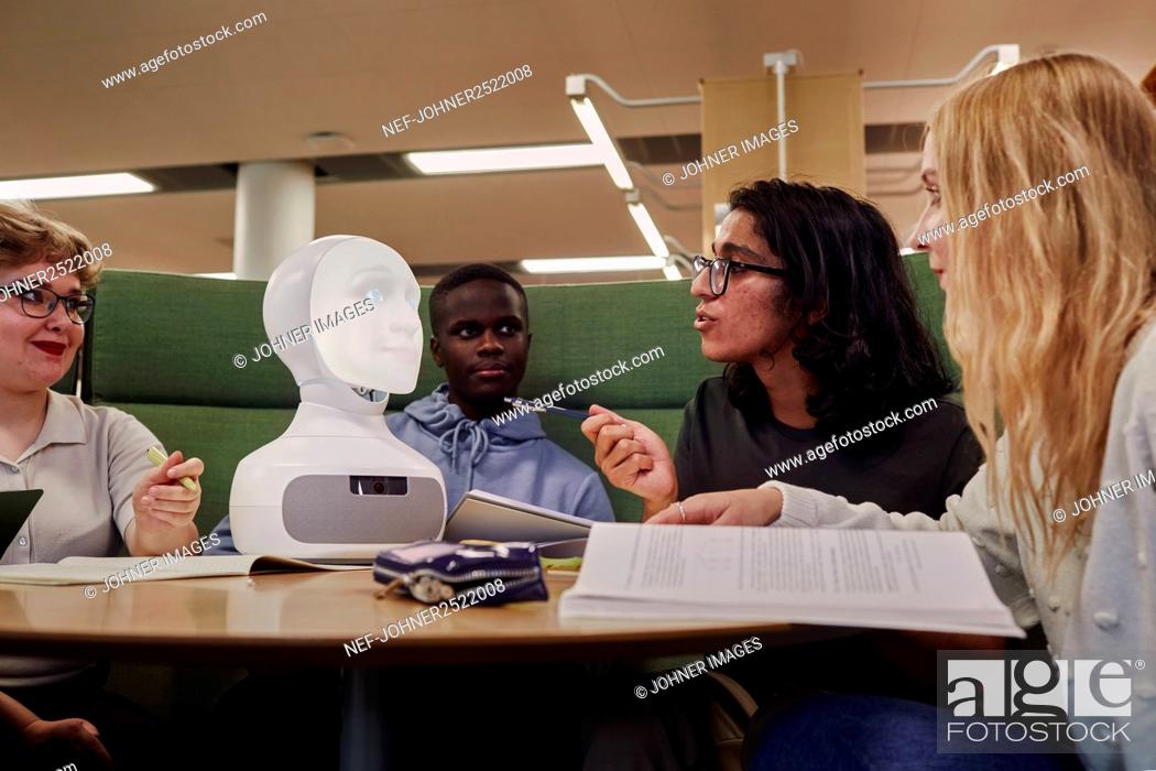 Stock Photo: Friends sitting together in library.