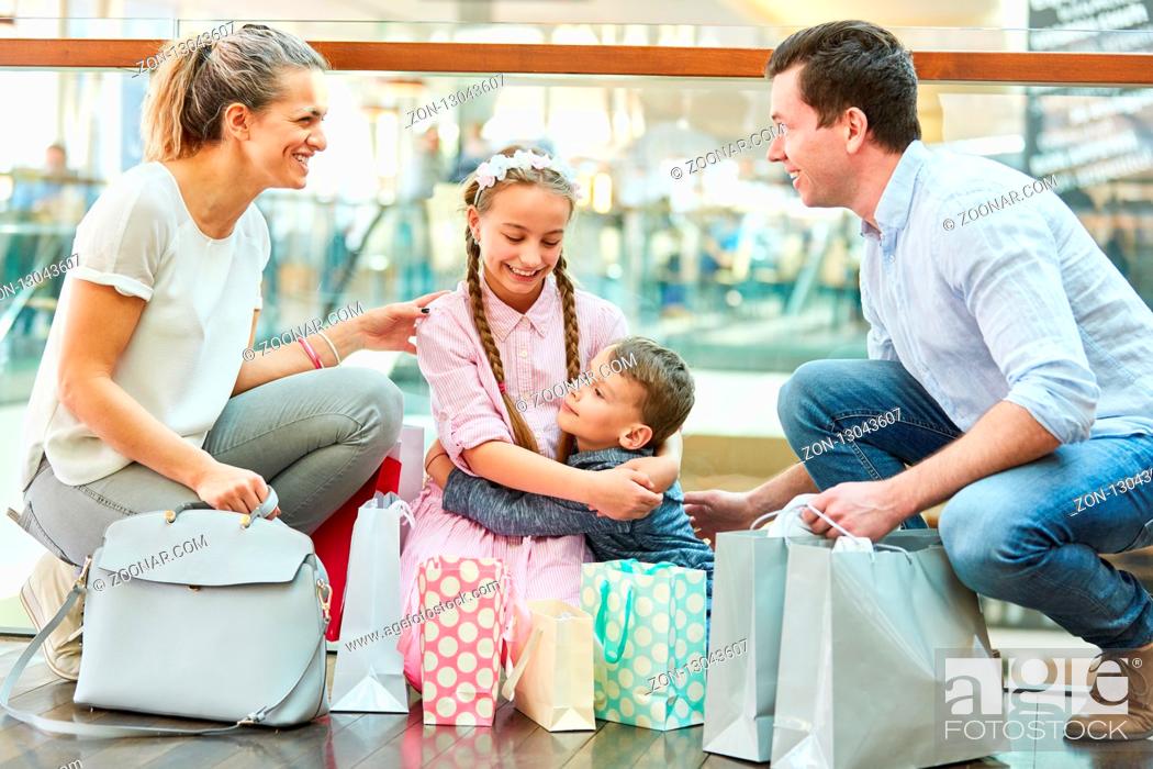 Photo de stock: Glückliche Familie im Shoppingcenter mit vielen Einkaufstüten und Geschenken.