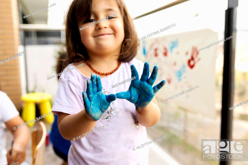 Stock Photo: Little girl messing around with her painted hands.