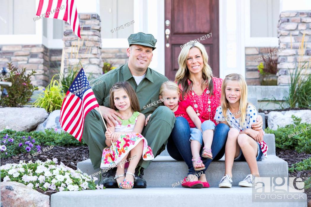 Stock Photo: Caucasian soldier and family smiling together on front stoop.