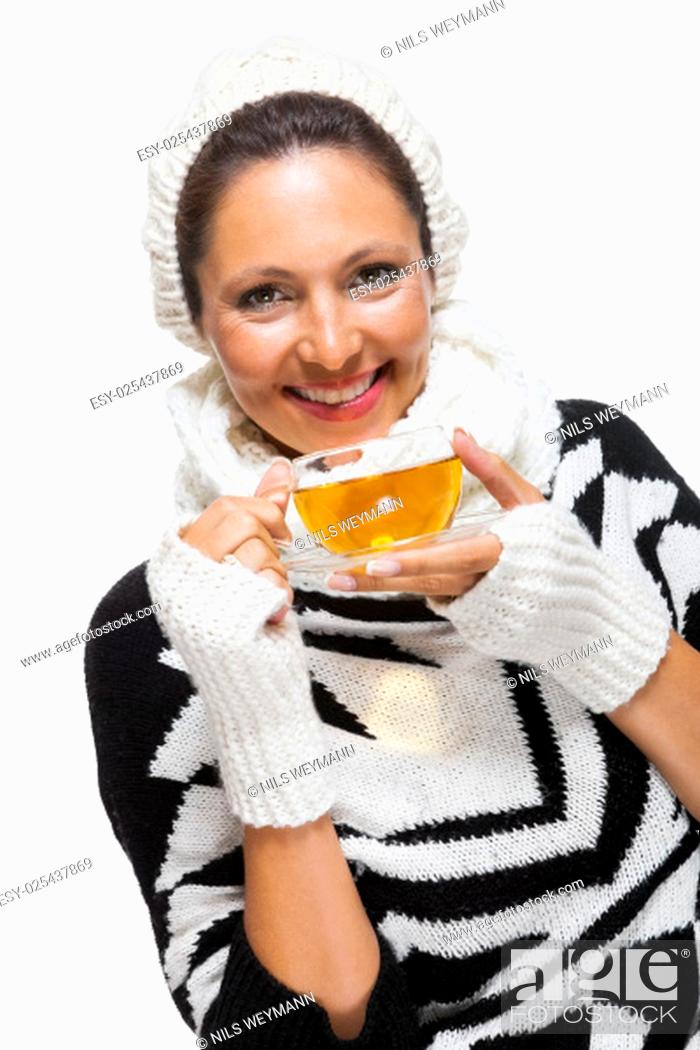 Stock Photo: young brunette woman with white wool hat drinking a cup of tea to warm up isolated on white background.